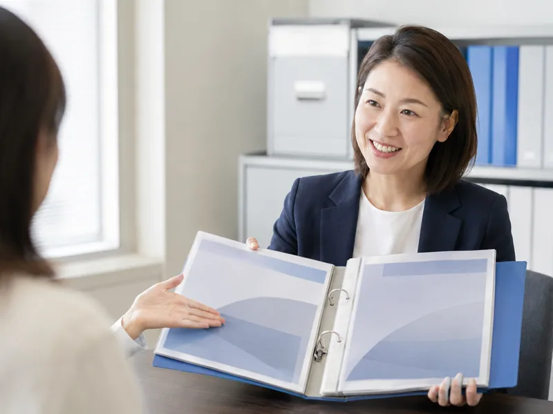 書類をファイルで示しながら説明する担当者